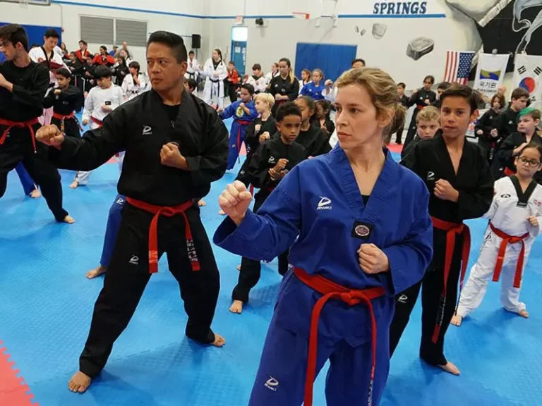 Adult students practicing punches in group martial arts for adults class