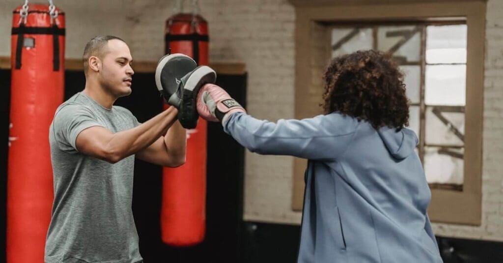 Student practicing punches with focus mitts during self defense basics training