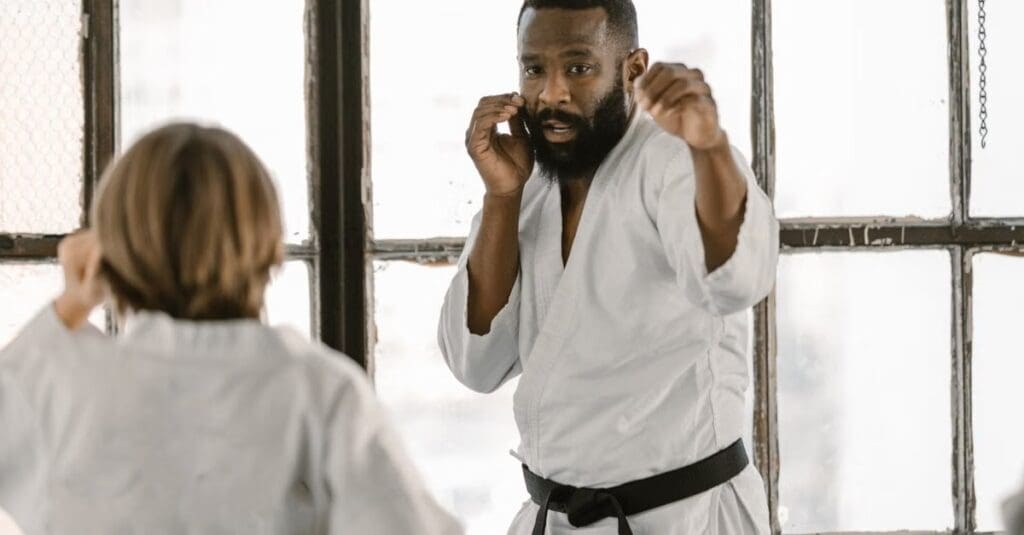 Instructor practicing a guarded fighting stance with a student during training in taekwondo technique fundamentals for beginners.