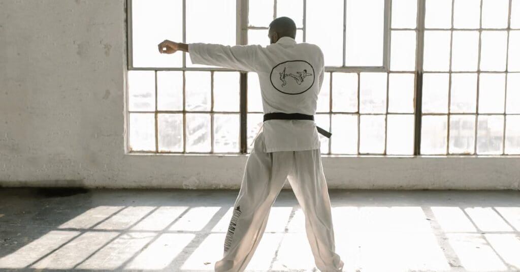 Martial artist practicing a straight punch and balanced stance during solo training in taekwondo technique fundamentals for beginners.