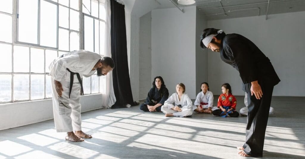 Instructor and student bowing respectfully before class while learning discipline through taekwondo technique fundamentals for beginners.